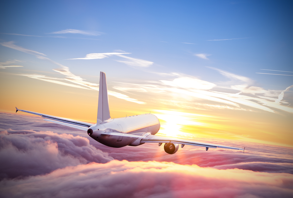 A plane flying into the sunset 