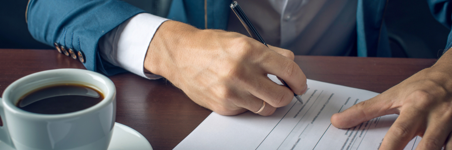 man writing something on a piece of paper